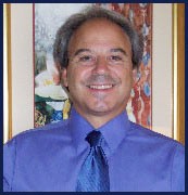 A Man in a Blue Shirt and Tie Stands in Front of a Colorful Painting